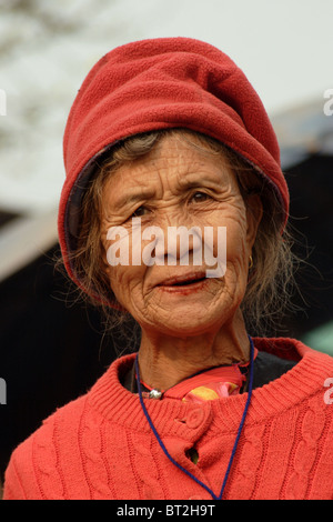 Eine ethnische Hügel Stamm Frau trägt eine rote Mütze an einem kalten Tag in Sappong (Pang Ma Pha) Nord-Thailand. Stockfoto