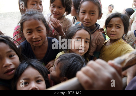 Jungen und Mädchen an einer Grundschule betrachten in einem Fenster nach Aussparung Lernende Institution in kommunistische Laos. Stockfoto