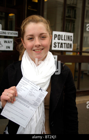 Ersten Mal Wähler zeigt stolz Stimmkarte vor einem Wahllokal Stockfoto