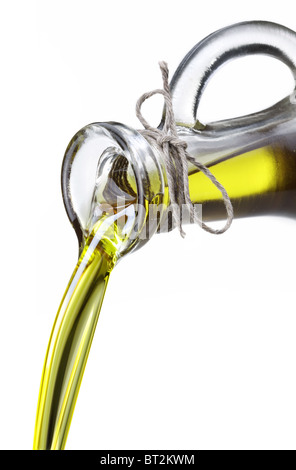 Olivenöl aus Karaffe in den Löffel isoliert auf einem weißen fließen. Stockfoto