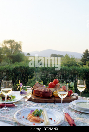 gut gedeckten Tisch mit Gläsern Weißwein und Teller mit Essen Stockfoto