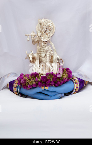 Indische Mädchen hält eine Silber Krishna Statue mit blauen Zeiger Stockfoto