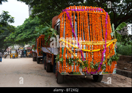 Indische Lastwagen in Blumengirlanden, vorbereitet für hinduistische Dasara festival Puja, bevor Sie eine Reise abgedeckt. Puttaparthi, Andhra Pradesh, Indien Stockfoto