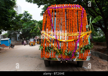 Indische Lastwagen in Blumengirlanden, vorbereitet für hinduistische Dasara festival Puja, bevor Sie eine Reise abgedeckt. Puttaparthi, Andhra Pradesh, Indien Stockfoto