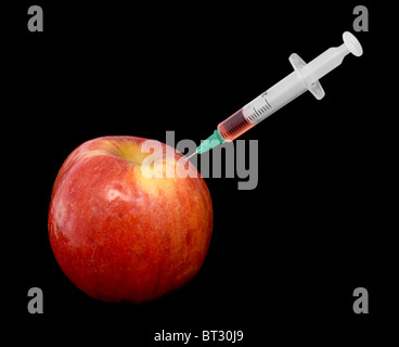 Roter Apfel mit einer Spritze auf schwarzem Hintergrund Stockfoto