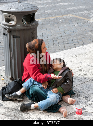 Frau mit einem Kind Betteln auf der Straße bei St.-Peter Platzes, Rom, Italien. Stockfoto