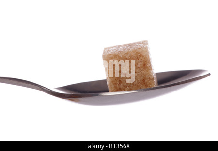 Ein brauner Zuckerwürfel auf einen Tee-Löffel-Ausschnitt Stockfoto