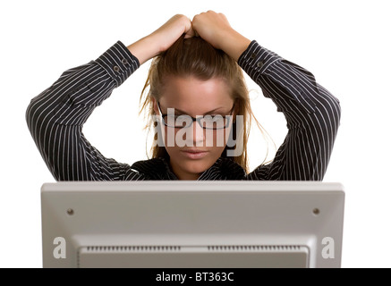 Eine junge Büroangestellte zieht ihr Haar in der Frustration von einem Computer-Crash. Stockfoto