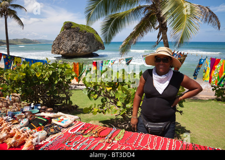 Frau mit Souvenirs in Bathsheba Beach mit der Mushroom Rock im Hintergrund Stockfoto