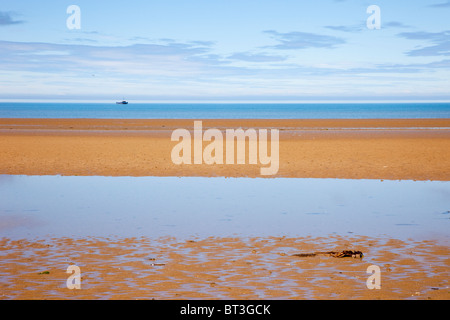 Generic Red Wharf Bay mit Pool auf sandigen Strand bei Ebbe und Boot offshore in unberührter, blauen Meer. Llanddona, Isle of Anglesey, North Wales, UK Stockfoto