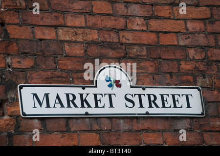 Straßenschild an einer Ziegelwand in einer englischen Stadt befestigt. Stockfoto