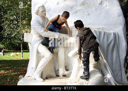 Kinder klettern auf die Statue zu Chopin im Parc Monceau, Paris. Stockfoto