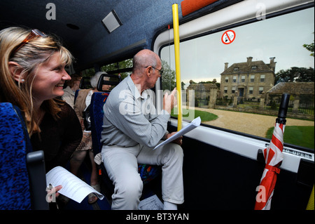 Die Tirley Gemeinschaft "Jillywood" Bustour - Tour Guide Derrick Schwan (rechts) weist darauf hin Nether Lypiatt Manor ehemalige Heimat von Princ Stockfoto