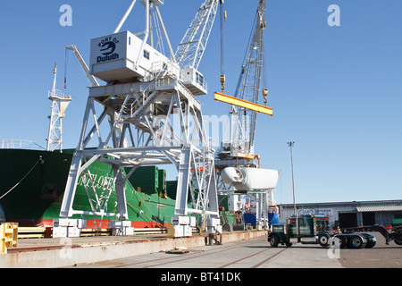 ein Wind-Turbine-Motor wird von einem Schiff auf eine halb in einem Hafen in Duluth, Minnesota entladen wird Stockfoto