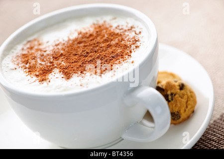 Cappuccino oder Latte, die in Tasse mit Milchschaum und Cookies Kaffee Stockfoto