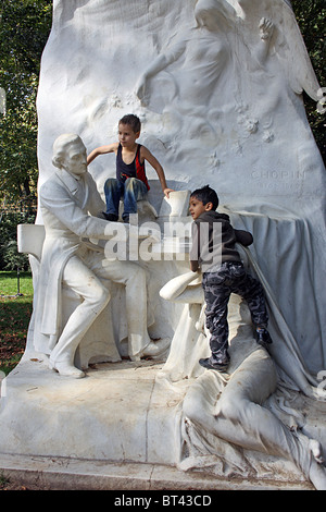 Kinder klettern auf die Statue zu Chopin im Parc Monceau, Paris. Stockfoto