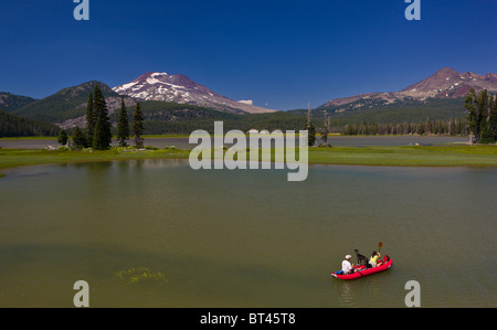 SPARKS LAKE, OREGON, USA - Mensch und Hund auf Floß, South Sister, ein Vulkan in den Kaskaden Bergen von Zentral-Oregon. Stockfoto