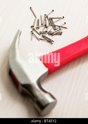 Nägel und Hammer auf Holzboden. Erhöhte Ansicht Stockfoto