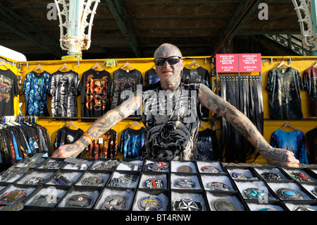 Stark tätowierte Mann an seinem Gürtelschnalle Stall, Brighton, Oktober 2010 Stockfoto