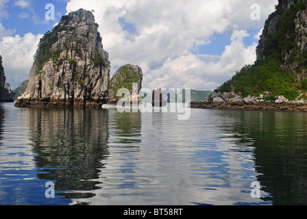 Dschunke mit roten Segel unter Kalksteininseln in Ha Long Bucht, Vietnam Stockfoto