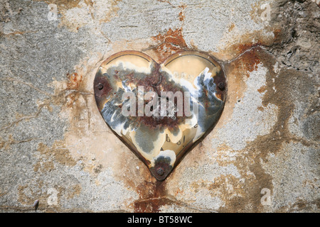 Eine alte Herz Ornament auf einer Steinmauer auf einer französischen Grabstätte hautnah. Stockfoto