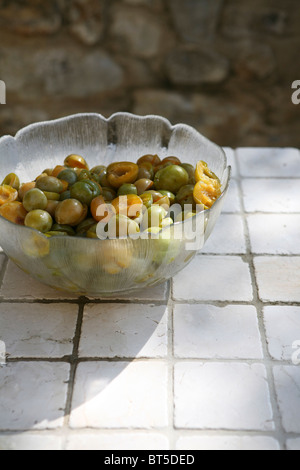 (Prunus X domestica var. Syriaca) Halbierten und entsteinten Mirabellen in eine Glasschüssel. Stockfoto