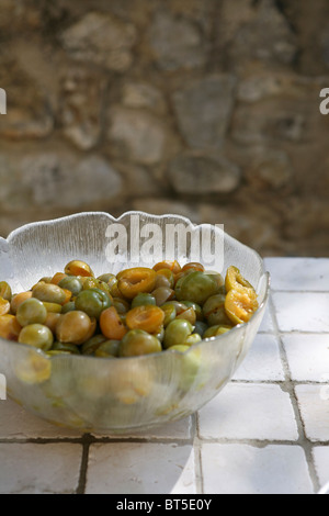 (Prunus X domestica var. Syriaca) Halbierten und entsteinten Mirabellen in eine Glasschüssel. Stockfoto