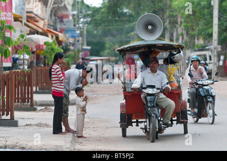 Eine Mobile buddhistische Nonne bietet Segen Pässe durch aus eine Autorikscha auf den Straßen von Siem Reap, Kambodscha Stockfoto