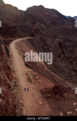 Zwei Menschen gehn auf einen Schotterweg durch die felsige Landschaft in der Nähe von Lake Mead und den Hoover-Staudamm Stockfoto