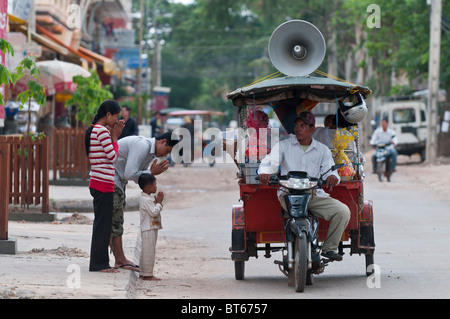 Eine Mobile buddhistische Nonne bietet Segen Pässe durch aus eine Autorikscha auf den Straßen von Siem Reap, Kambodscha Stockfoto