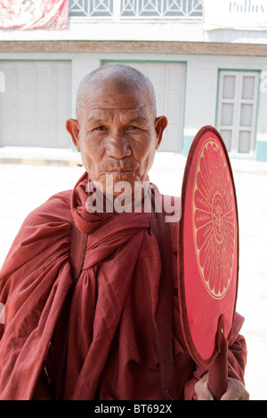 Alte buddhistische Mönch Posen während auf seine Morgen Almosen Stockfoto