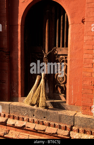 Besen gegen Fenster des Gebäudes in die UNESCO-Welterbe-Stadt von Bhaktapur - Kathmandu-Tal, Nepal. Stockfoto