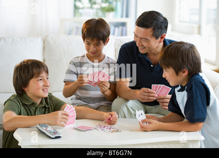 Vater und Söhne Spielkarten im Wohnzimmer Stockfoto