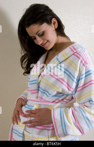 Porträt schwangere junge Mutter im Bademantel Stockfoto