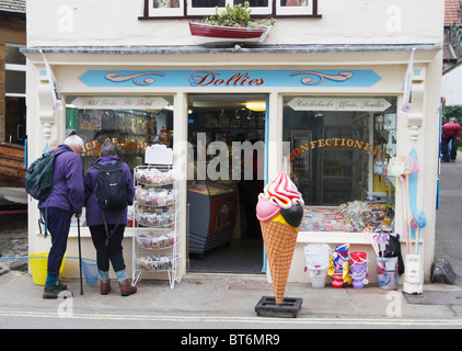 Reifes Paar in Laufausrüstung vor Dollies Süßigkeiten und Süßwaren-Shop in Robin Hoods Bay, North Yorkshire Stockfoto