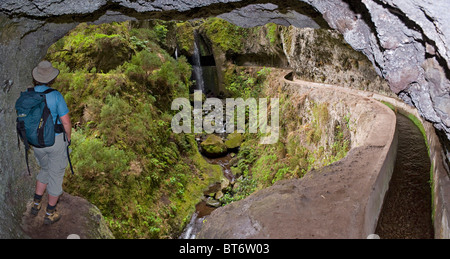 Wanderer, Blick auf den Wasserfall auf der Levada Nova aus einem Tunnel, Lombada da Ponta do Sol, Madeira, Portugal Stockfoto