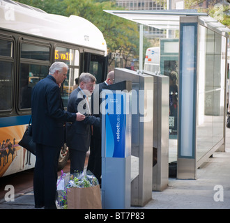 Pendler kaufen Tarife vor dem Einsteigen in eines Bus-Service wählen Sie Bus auf Second Avenue in Midtown in New York Stockfoto