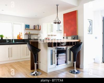 Schwarz und Chrom "Bombo" Hocker am Frühstücks-Bar auf Halbinsel Einheit mit gekühlten Wein Lagerung in modernen Küche-Erweiterung Stockfoto