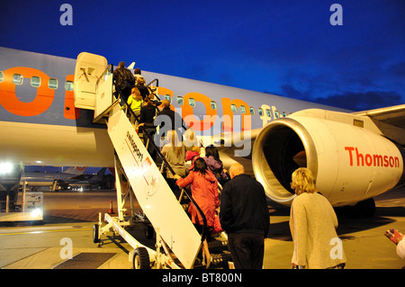 Passagiere, die Thomson Boeing 757-200 Flugzeug, Flughafen Gatwick, Crawley, West Sussex, England, Vereinigtes Königreich Stockfoto