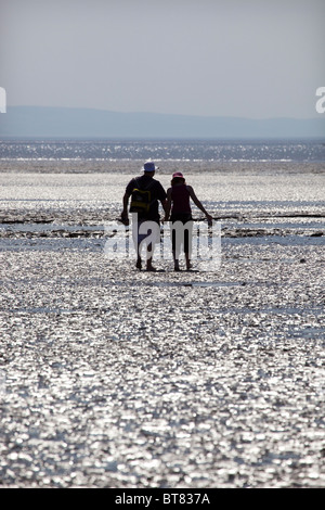 Paar Strand entlang spazieren Hand in Hand Stockfoto