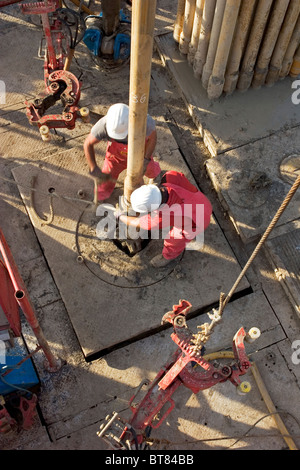 Onshore-Öl und Gas Exploration Rig Website. Blick hinunter auf Besatzungsmitglieder Anschluss Rohr während des Bohrens. Uganda Stockfoto