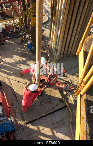 Onshore-Öl und Gas Exploration Rig Website. Blick hinunter auf Besatzungsmitglieder Rohr mit Kette Tong während des Bohrens zu verbinden. Uganda Stockfoto