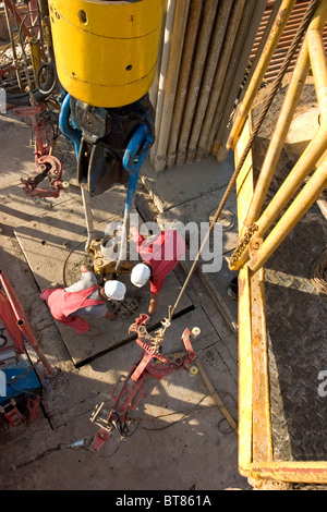 Onshore-Öl und Gas Exploration Rig Website. Blick hinunter auf Besatzungsmitglieder Rohr mit Kette Tong während des Bohrens zu verbinden. Uganda Stockfoto