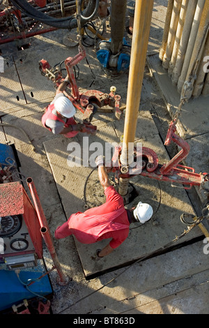 Onshore-Öl und Gas Exploration Rig Website. Blick hinunter auf Besatzungsmitglieder Rohr mit Kette Tong während des Bohrens zu verbinden. Uganda Stockfoto