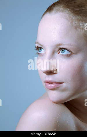 Junge Frau, die Wassertropfen auf ihrer Haut Stockfoto