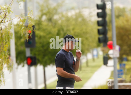 Mann mittleren Alters Rauchen einer Marihuana-Zigarette auf öffentlicher Straße. Stockfoto