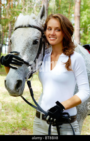Bild von glücklich weiblichen Blick in die Kamera mit Pferd in der Nähe von Stockfoto