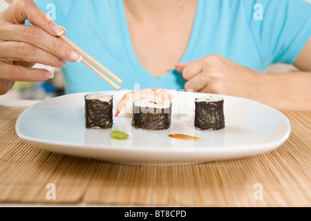 Abschnitt einer Frau, Sushi-Essen Stockfoto