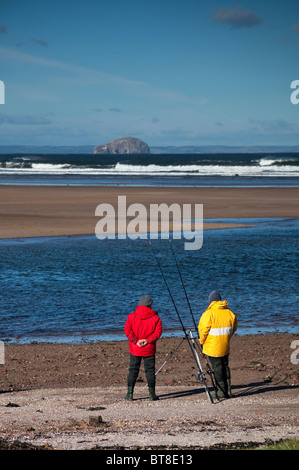 Zwei Männer in bunten Jacken Hochseeangeln Belhaven Strand, East Lothian Schottland, UK, Europa Stockfoto