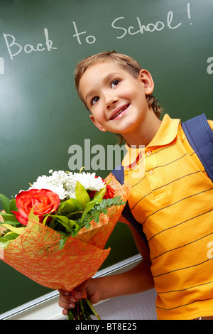 Porträt von smart Schulkind mit Blumenstrauß von der Tafel Stockfoto